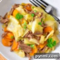 Comforting Cabbage Stew 5 A plate of hearty cabbage stew, beautifully arranged with tender cabbage, vibrant carrots, and savory shredded meat, delicately garnished with fresh parsley, with a fork resting invitingly on the side.