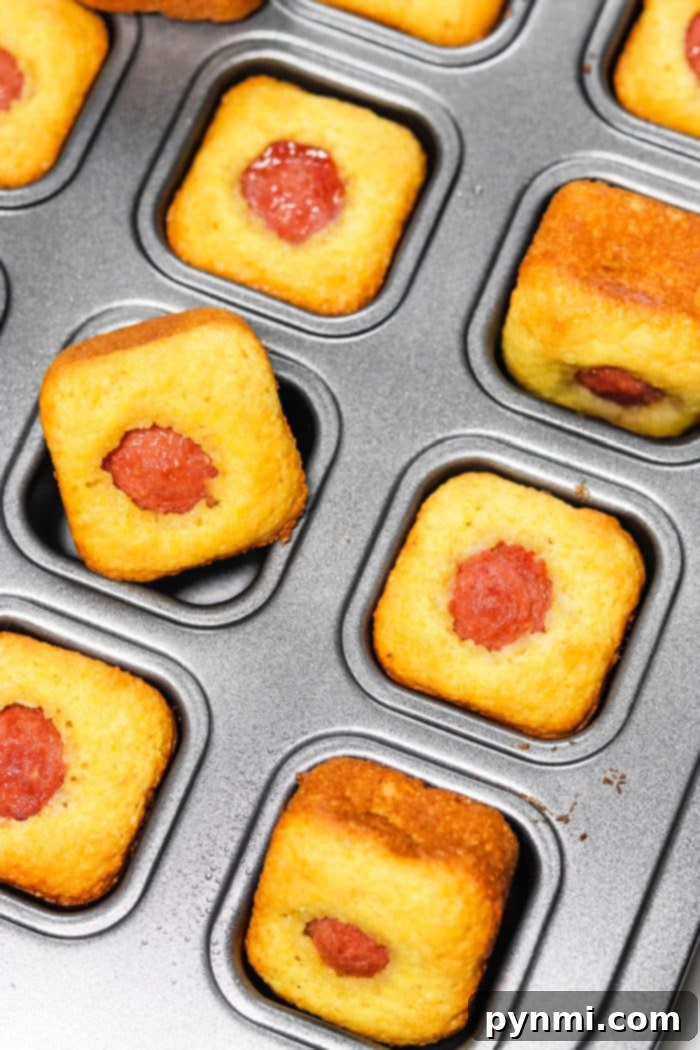 Golden brown Jiffy Corn Dog Bites, freshly baked in a mini muffin tin, ready to be served.