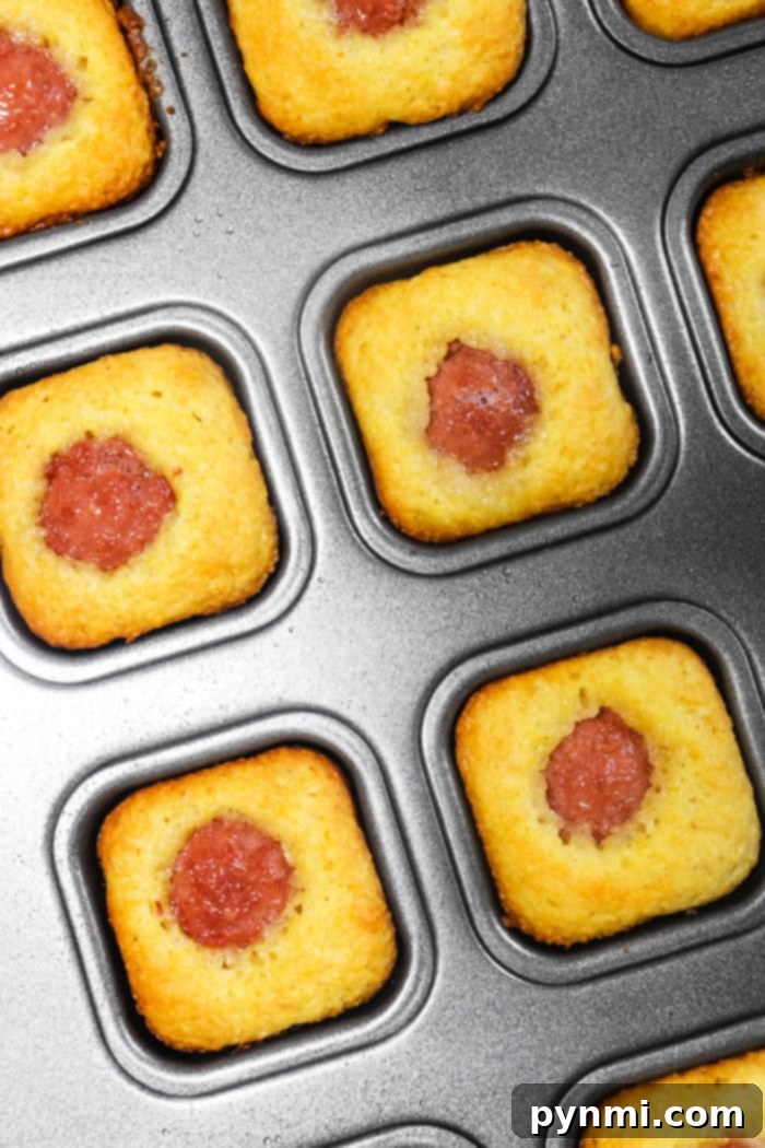 A plate of Jiffy Corn Dog Muffins with ketchup for dipping, perfect for a family meal or party.