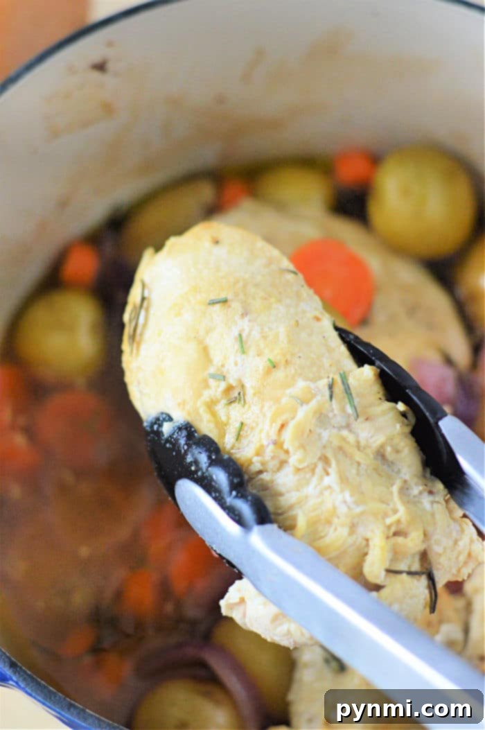 Perfectly Tender Dutch Oven Chicken Breasts 7 Closeup shot of fork-tender chicken and soft vegetables, ready to be served from the Dutch oven