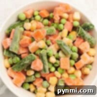 Discover how to cook frozen vegetables with this enticing mix of peas, carrots, corn, and green beans—all perfectly combined in one bowl.