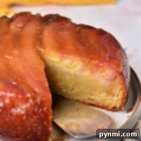 Close-up of a sliced Banana Upside Down Cake on a plate, featuring a caramelized glaze and vibrant yellow fruit topping.