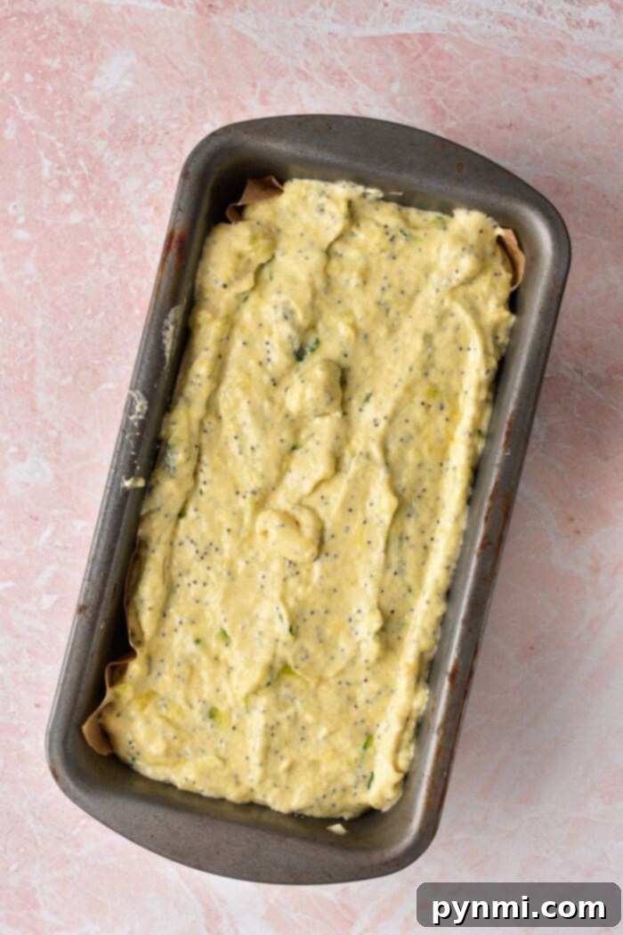 Zesty Lemon Zucchini Loaf 8 A close-up of moist lemon zucchini bread with a vibrant lemon zest garnish.