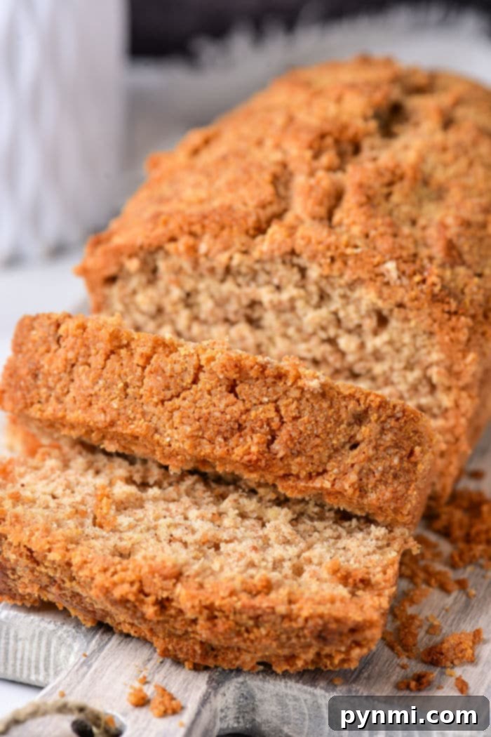 Sliced healthy coffee cake, rests on a wooden board, crumbs artfully scattered around.