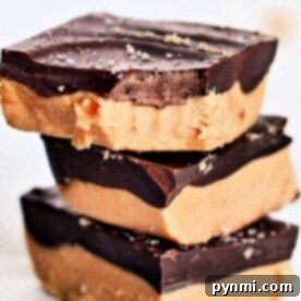 Three stacked pieces of rich peanut butter chocolate fudge with flaky salt on top, reminiscent of the nostalgic Lunch Lady Peanut Butter Bars.