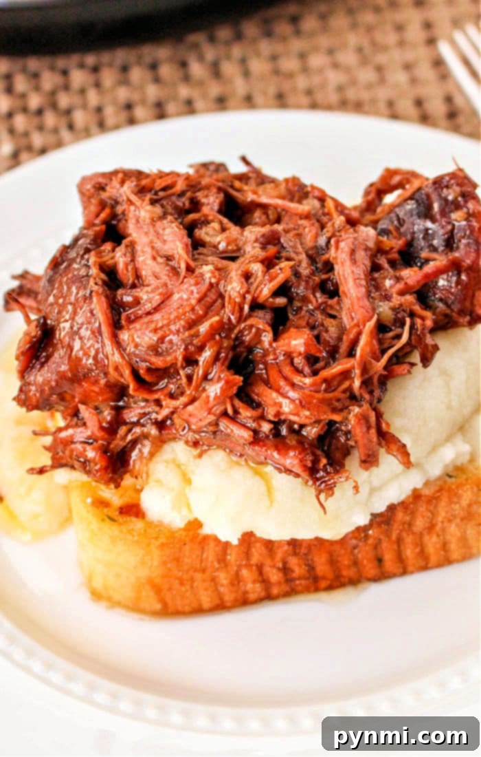 Slow Cooker Beef Manhattan: A hearty serving of shredded beef on garlic toast with mashed potatoes.