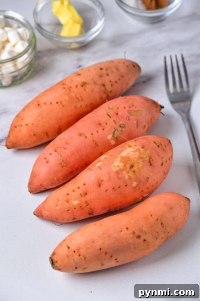The Perfect Bake Time for Sweet Potatoes at 400 Degrees 3 Four raw sweet potatoes rest on a white surface with a fork nearby, ready to reveal how long to bake a sweet potato at 400.