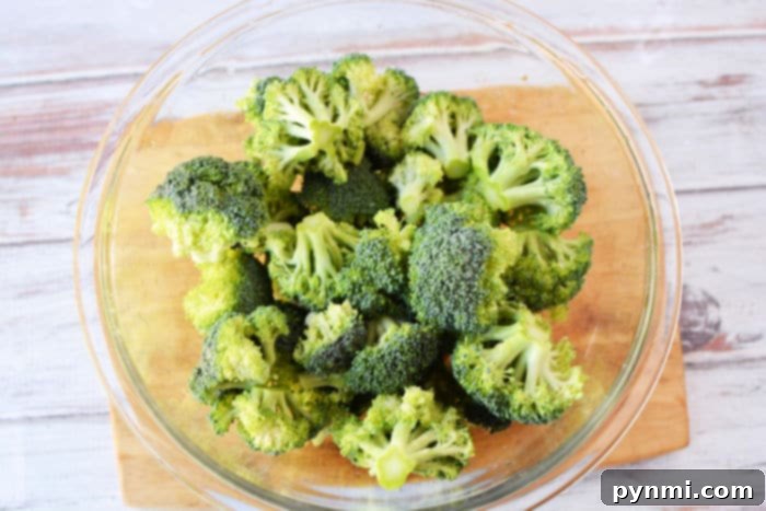 Fresh broccoli florets neatly arranged in a microwave-safe bowl, ready for cooking.