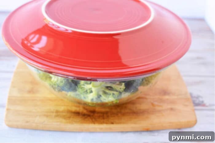A microwave-safe bowl with perfectly steamed broccoli, fork-tender and vibrant.