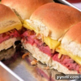 A baking dish filled with delicious Roast Beef Sliders, featuring tender beef, melted cheese, and perfectly sautéed onions.