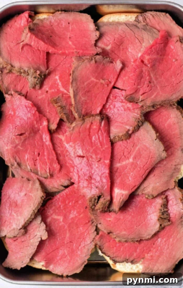 The Ultimate Melt-in-Your-Mouth Roast Beef 8 How to Cook Melt in your Mouth Roast Beef - A generous serving of sliced roast beef with fresh rosemary.
