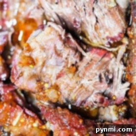 Close-up of juicy, tender smoked brisket with visible seasoning and a slightly charred crust, reminiscent of a perfectly prepared smoked chuck roast.