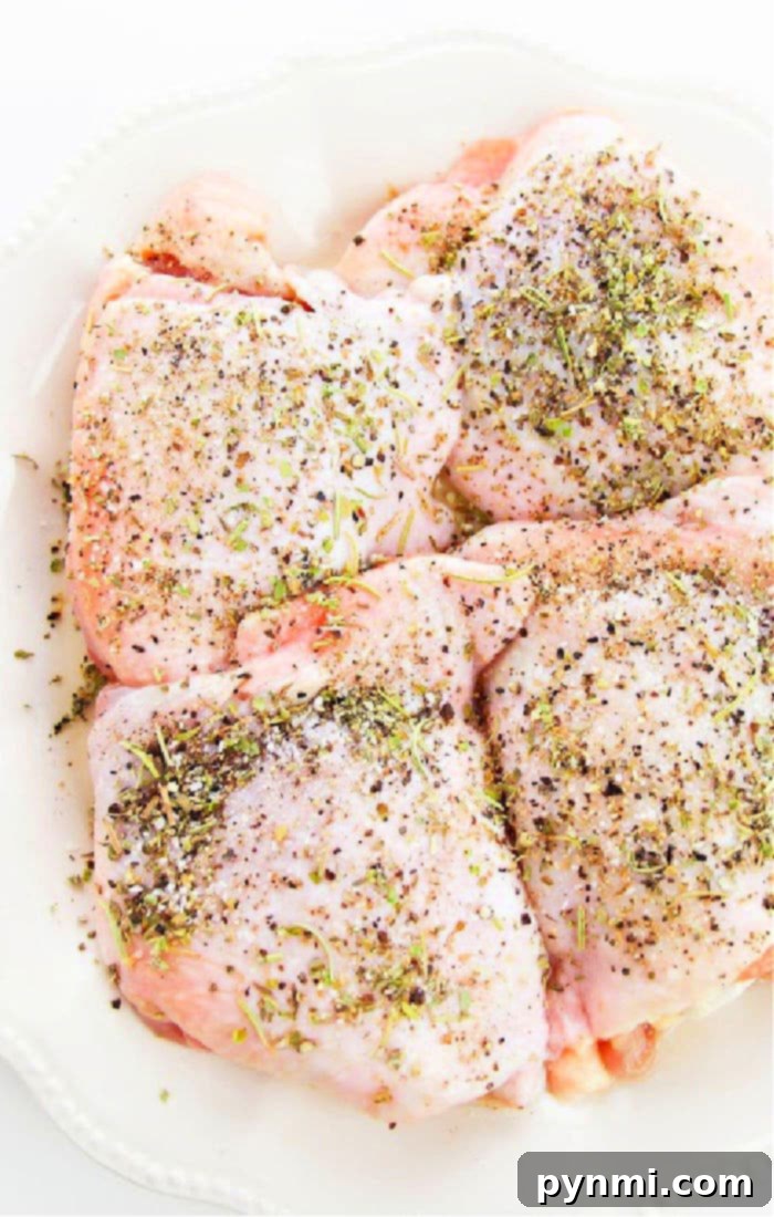 Perfectly cooked chicken thighs with crispy golden skin, garnished with fresh herbs, resting in a sizzling cast iron skillet. A visual guide for how long to cook chicken thighs on the stove for ideal tenderness.