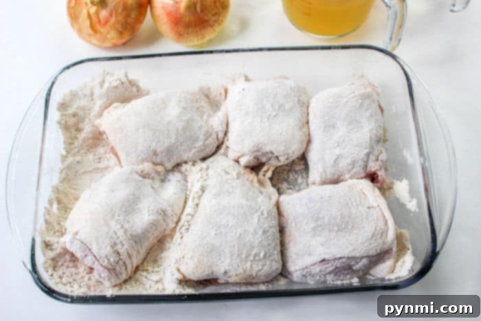 Skillet filled with bone-in chicken thighs sizzling, illustrating the crucial searing process for stovetop cooking. Essential steps for how to cook chicken thighs on stove for optimal results.