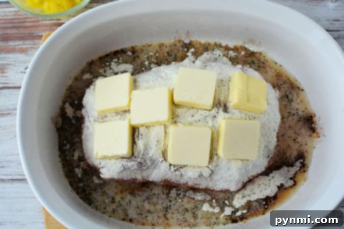A close-up view of a baked pork butt, golden brown and glistening with savory juices, showcasing its tenderness and rich texture.