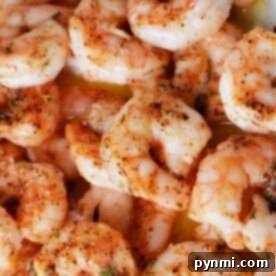 Discover the vibrant flavors of how to cook frozen raw shrimp, with each tender morsel seasoned perfectly with herbs and spices, captured in this close-up shot.