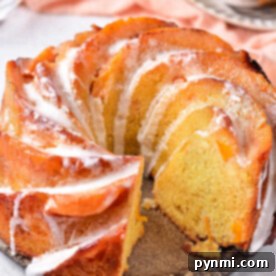 A sliced Peach Cobbler Pound Cake with icing drizzled on top, displayed on a light surface.