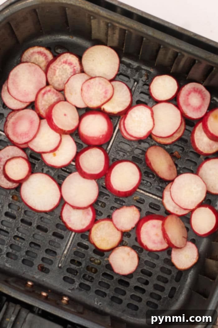 Radishes in Air Fryer - Sliced radishes spread in an air fryer basket