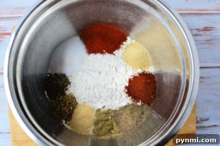 A selection of aromatic fried chicken seasonings in small bowls, ready for use.