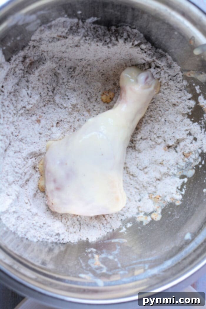 Golden-brown pan-fried chicken legs artfully arranged on a platter with fresh herbs.