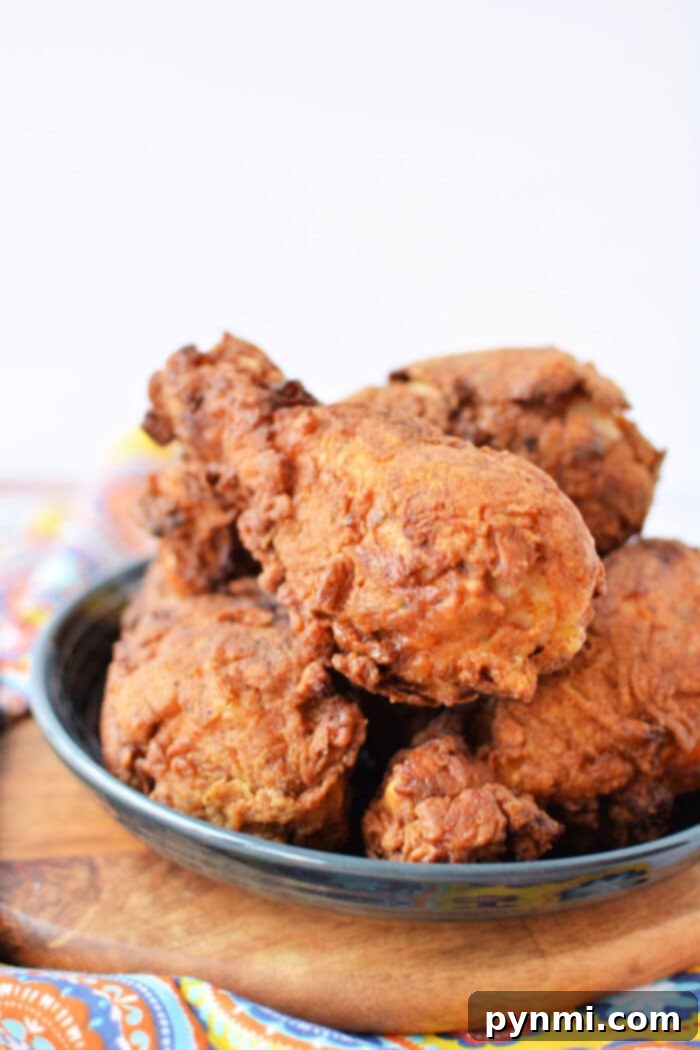 Perfectly pan-fried chicken legs with a golden, crispy crust in a cast iron skillet.