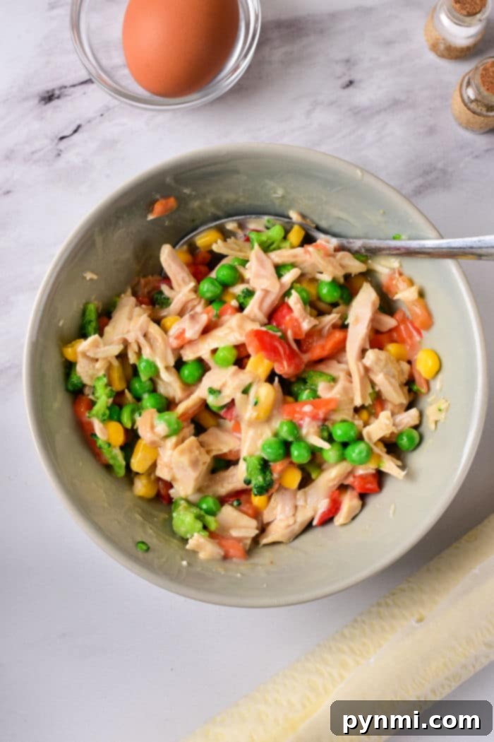 Handheld Air Fryer Chicken Pot Pie with flaky pastry, garnished with fresh herbs, ready for a quick meal.