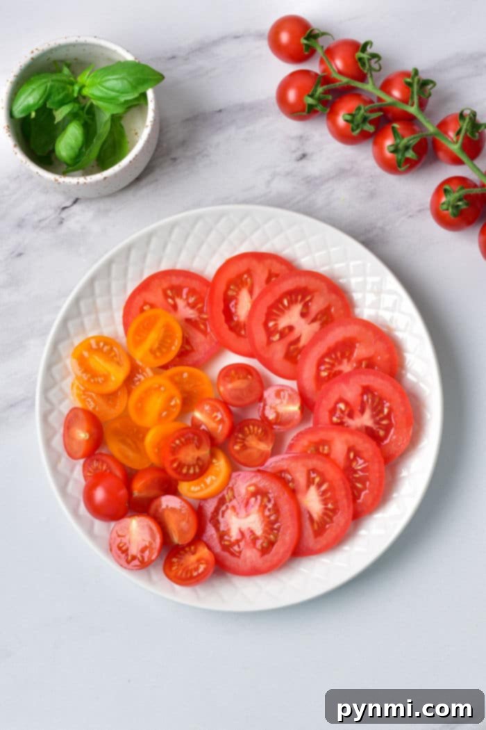 A beautifully arranged Burrata Caprese salad with bright red and yellow heirloom tomatoes, a creamy burrata ball, and vibrant green basil, ready for enjoyment.