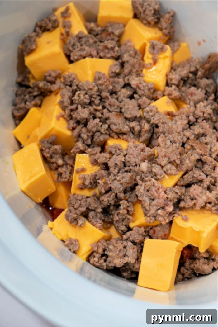 Creamy Velveeta Sausage Rotel Dip 4 A slow cooker filled with chunks of Velveeta cheese, crumbled cooked ground sausage, and Rotel tomatoes, ready to melt into an irresistible dip.