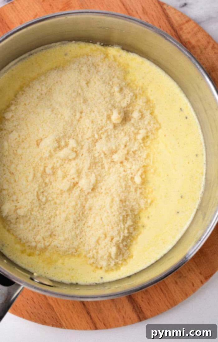Close-up of a pot of creamy Cajun Alfredo sauce with heavy cream, ready to be served.
