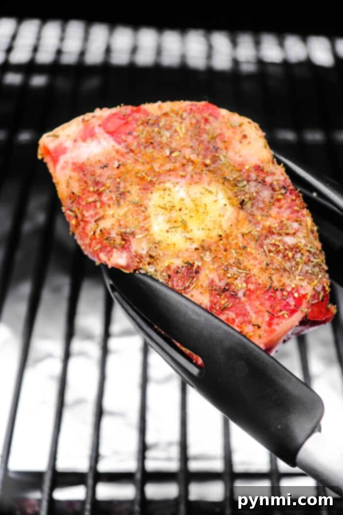 Traeger Oxtail cooking on the grill with visible smoke.