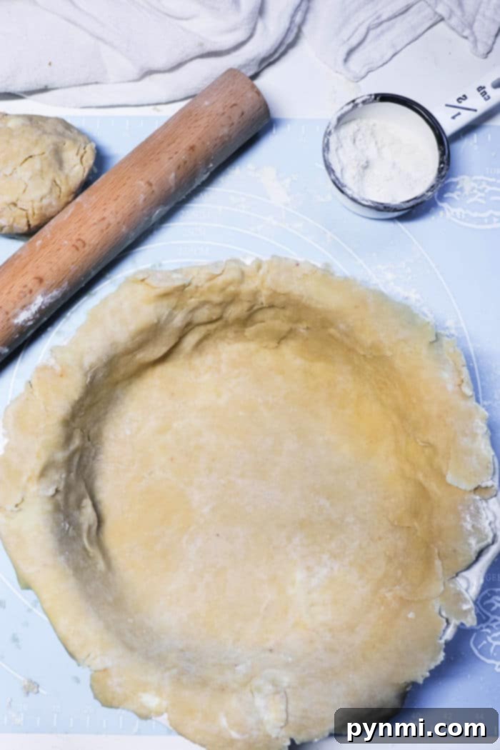 A close-up of fresh, raw pot pie crust dough, showcasing its texture, ready to be rolled out and filled, emphasizing the importance of a quality crust.