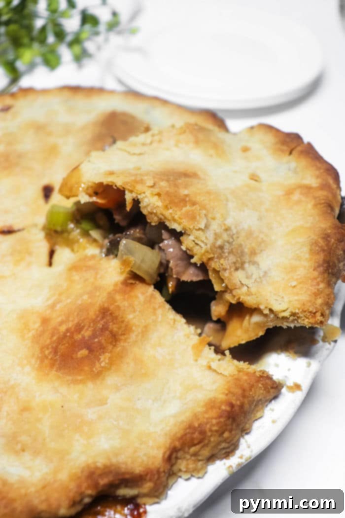 A perfectly baked double crust beef pot pie, golden and inviting, ready to be sliced and served, promising a hearty and comforting meal.