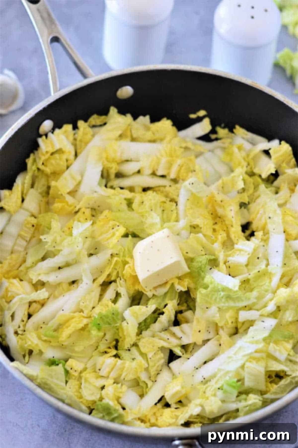 Napa Cabbage: Fresh Ideas and Recipes 5 Chopped Napa cabbage with a pat of butter and black pepper in a skillet, ready to be cooked—an easy and delicious Napa cabbage recipe.