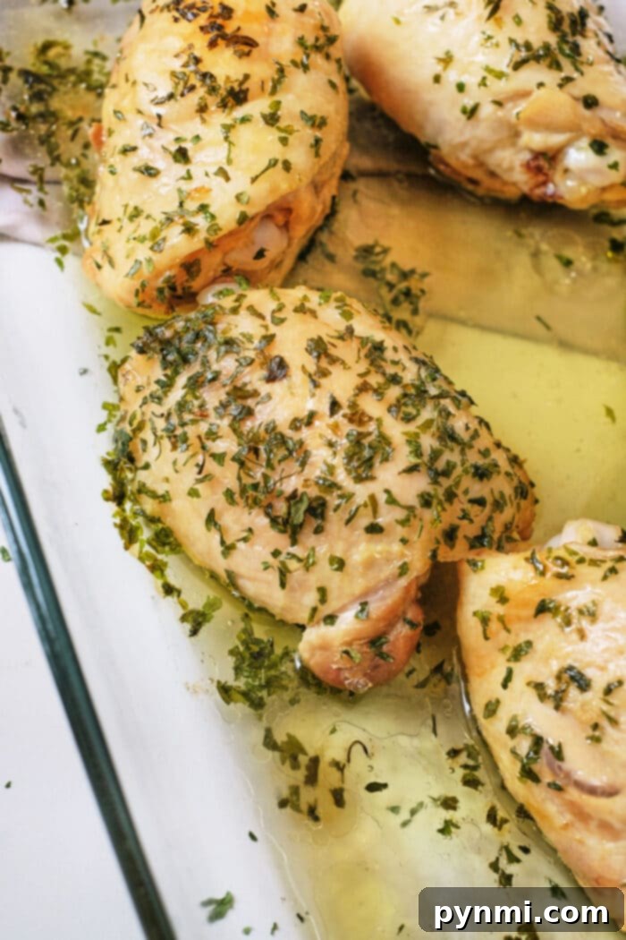 Boiling Chicken Thighs: Timing is Everything 7 Boiled chicken thighs with herbs and garlic in a glass dish, offering a flavorful alternative for those wondering how long to boil chicken thighs.