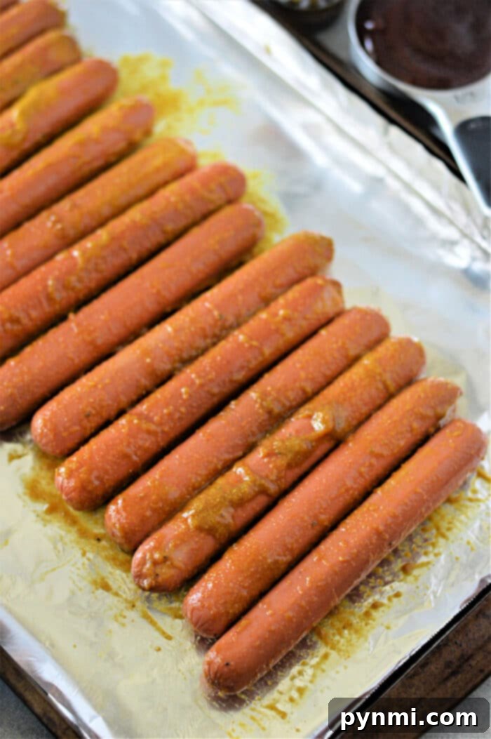 Close-up of hot dog pieces coated in dry rub, ready for baking into burnt ends.