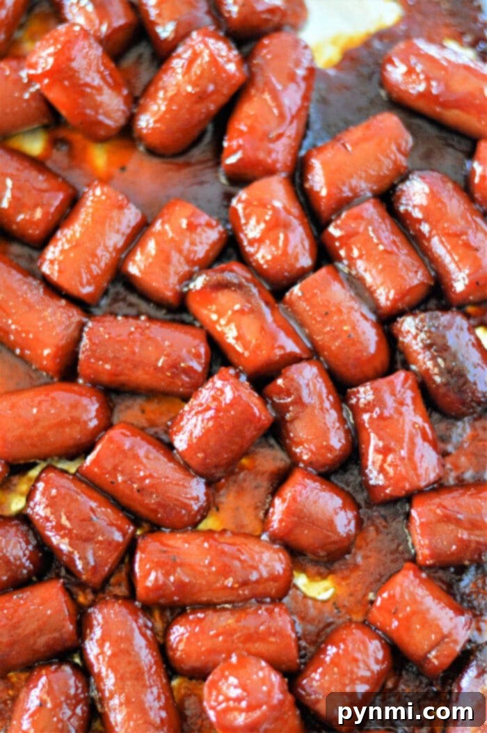 A close-up of hot dog burnt ends on a platter, showcasing their glossy, caramelized exterior.