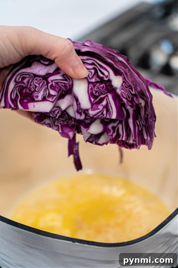 Close-up of buttered purple cabbage glistening in a Dutch oven, ready to be served, showcasing its appetizing appearance.