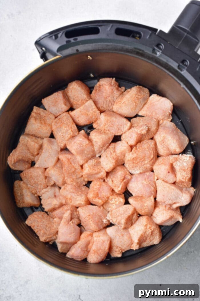 Air Fryer Buffalo Chicken Bites cooking in an air fryer basket, showing crispy texture