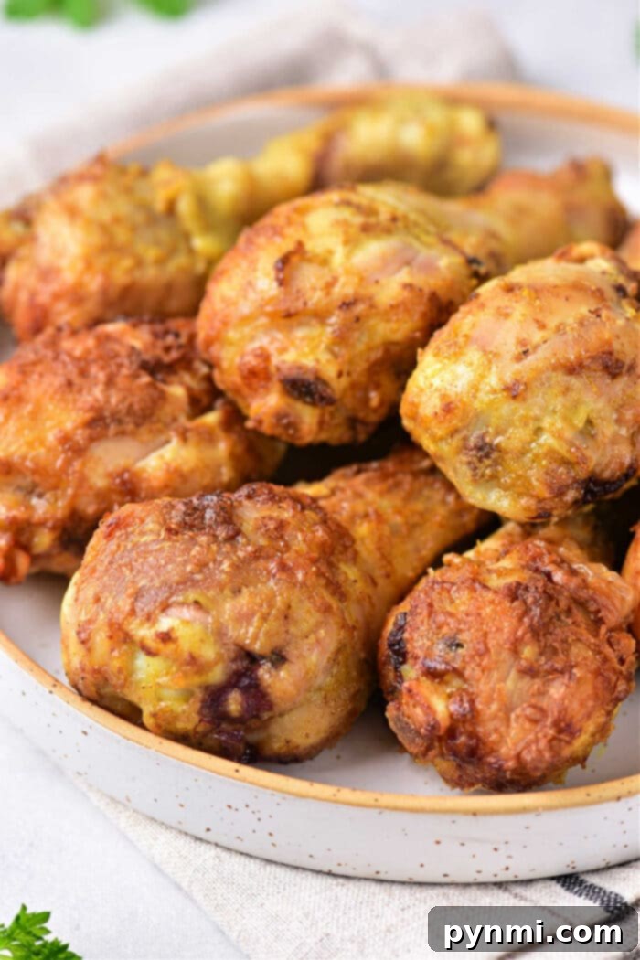 Crispy Air Fryer Curry Chicken 7 Close-up of crispy curry fried chicken drumsticks with a fork