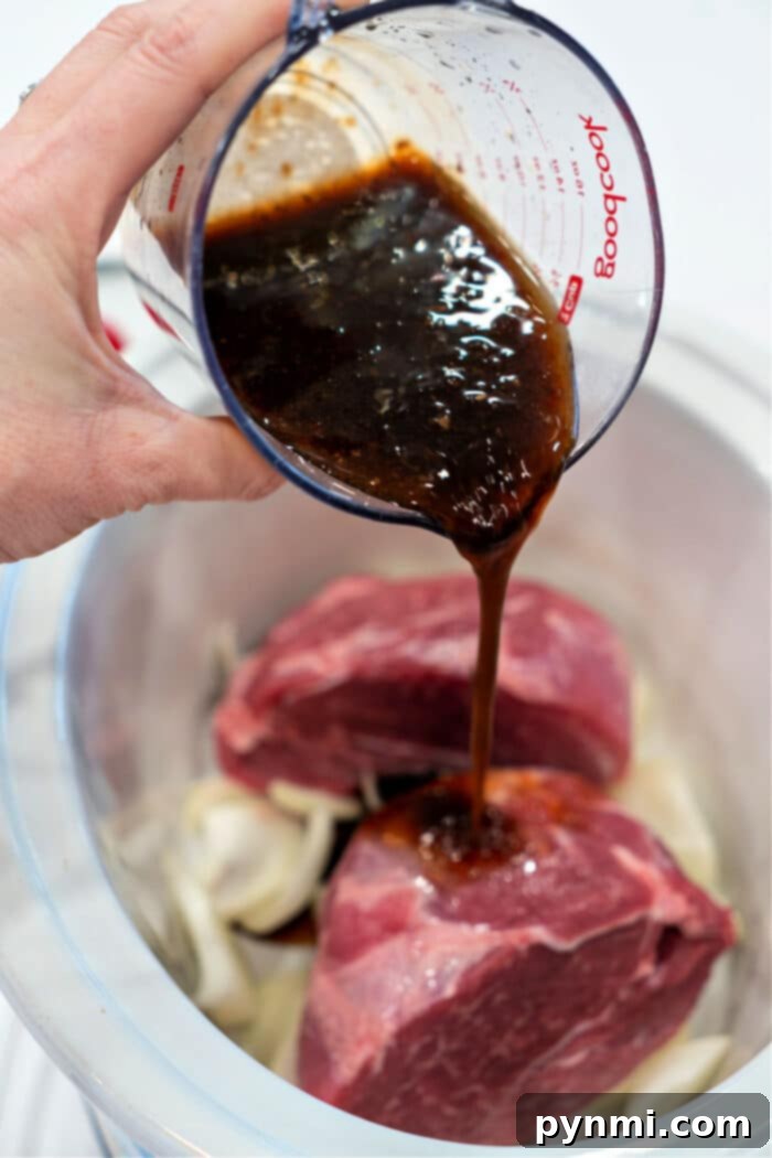 Mastering the Perfect Pork Picnic Roast 5 Pouring marinade over onions in a slow cooker, as if preparing a succulent pork picnic roast, infusing every layer with flavor.
