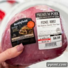 A hand holds a packaged Pork Picnic Roast, its label clearly displaying the price and weight.