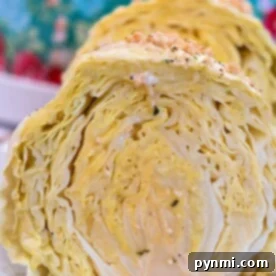A close-up showcases two cabbage halves on a plate, set against a floral-patterned background, evoking the cozy aroma of a whole head of cabbage slowly simmering in a slow cooker.