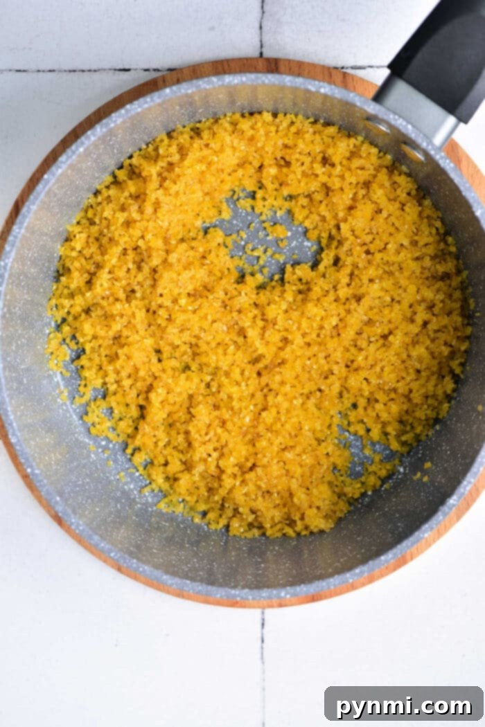 Unlock the Secrets to Fluffy Bulgur 3 A pot with cooked yellow bulgar wheat rests on a wooden board, reminiscent of how to cook bulgur wheat in its simplicity and flavor.