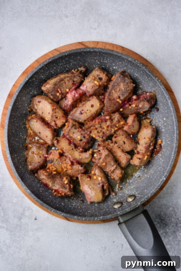 Slices of pork liver coated in a seasoned flour mixture, ready for pan-frying