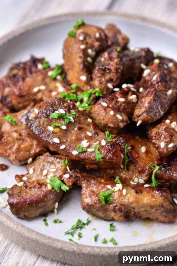 Close-up of a plate with perfectly cooked pork liver, garnished with fresh herbs, ready to be enjoyed.