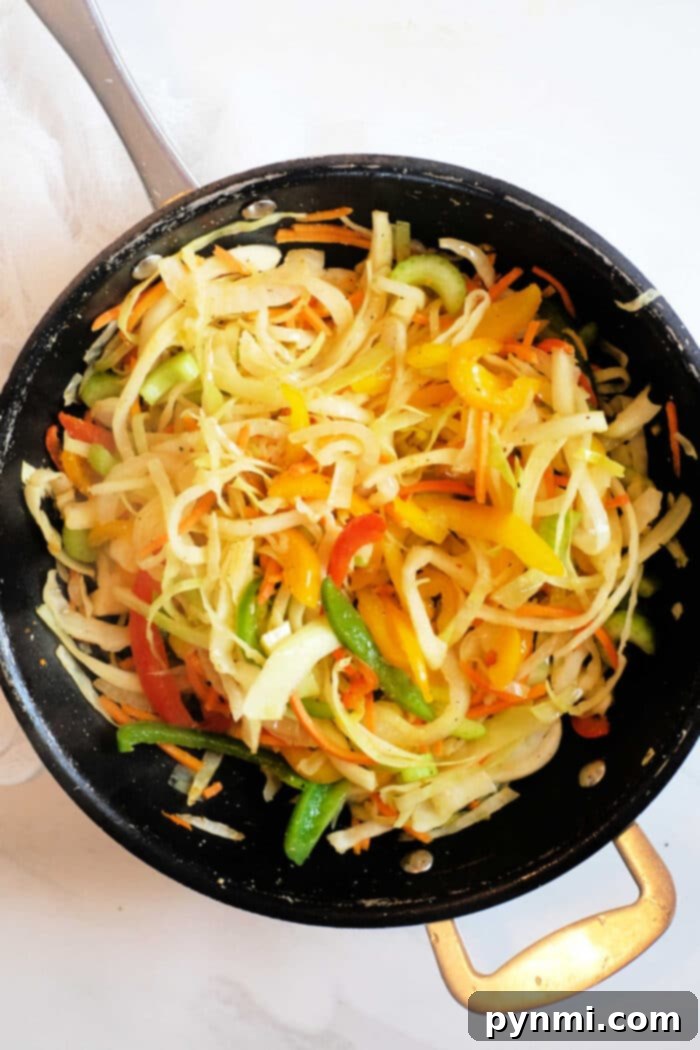 Vibrant Jamaican Cabbage 2 Caribbean fried cabbage recipe, showcasing a colorful mix of sautéed vegetables including bell peppers, onions, and zucchini.