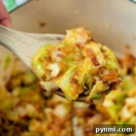 A wooden spoon lifts a delicious mixture, embodying the perfect cabbage and bacon recipe, right from the pot.