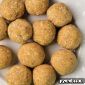 A cream-colored plate displaying round homemade matzo balls