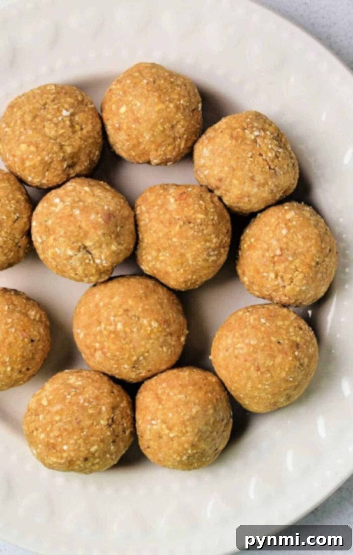 The Matzo Ball Demystified: History, How-To, and a Classic Recipe 8 Twelve round, golden-brown matzo balls, artfully arranged on a white, textured plate, emphasizing their homemade perfection.