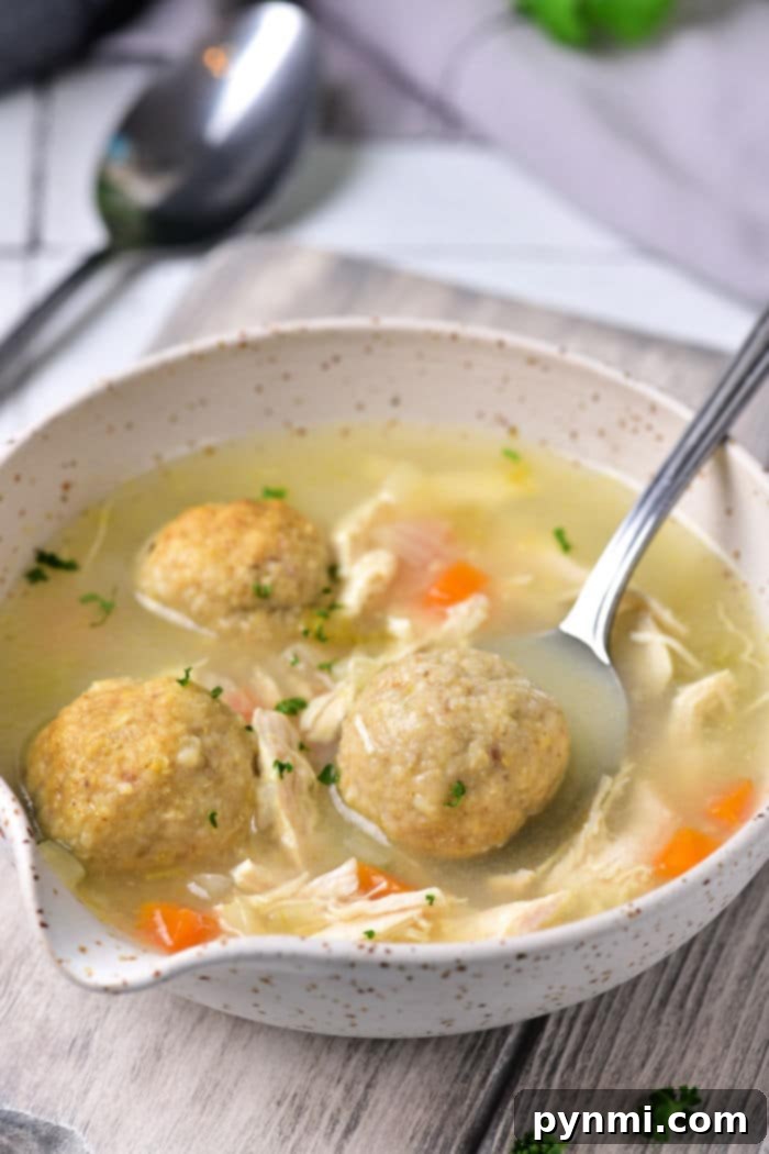 A vibrant bowl of Vegetarian Matzo Ball Soup, brimming with colorful vegetables like carrots and celery, and fluffy matzo balls, perfect for a meat-free option.